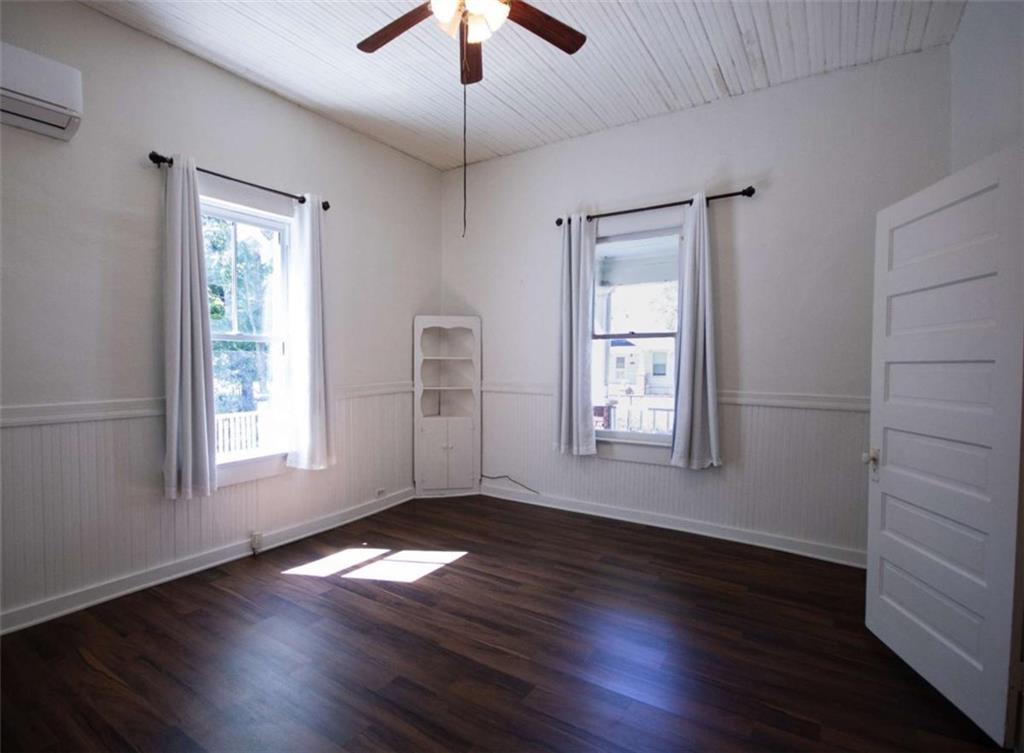 285 East Main Street Forsyth, GA 31029 - Photo 22 of 27 an empty room with wooden floor chandelier fan and windows