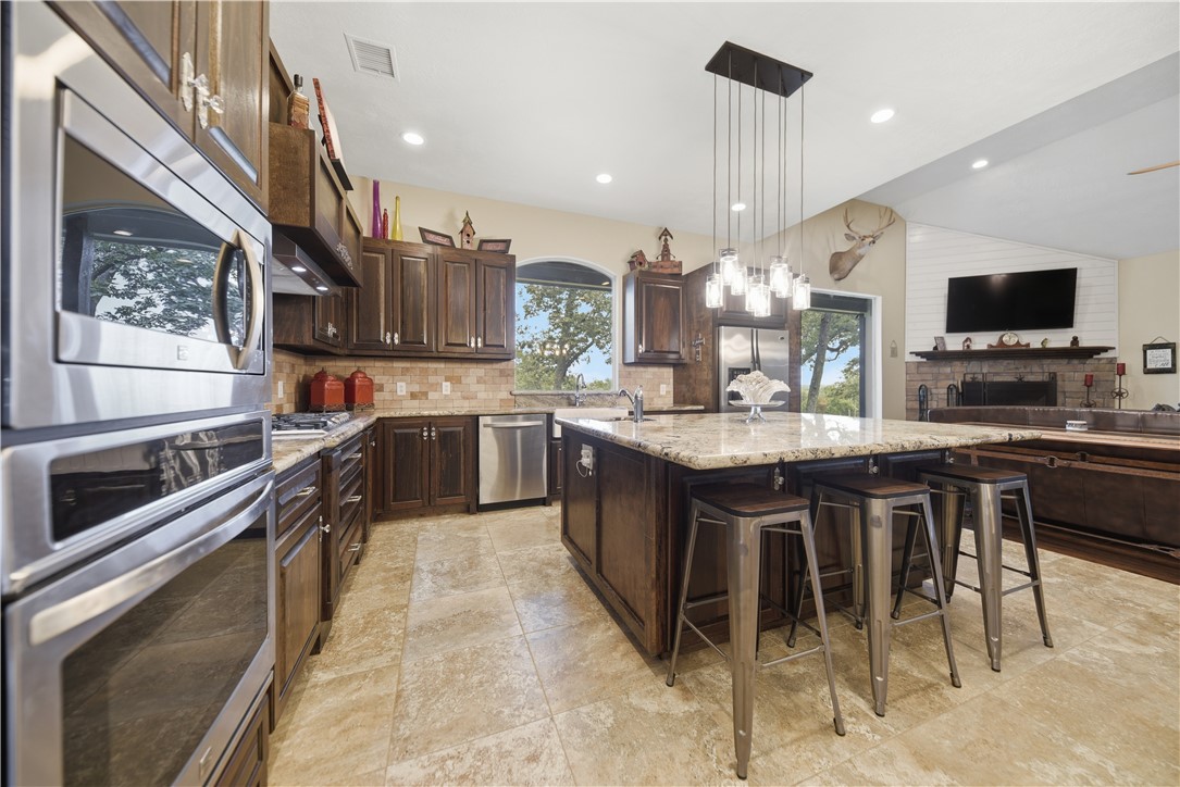8595 Jared Road Bellville, TX 77418 - Photo 10 of 45 Kitchen with stainless steel appliances, propane cooktop, custom cabinets, and large functional island