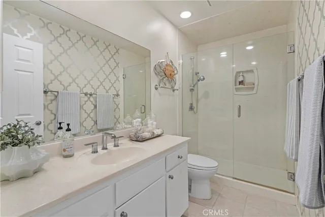 a bathroom with a double vanity sink toilet and shower