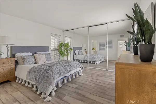 a living room with a balcony a bed and a potted plant