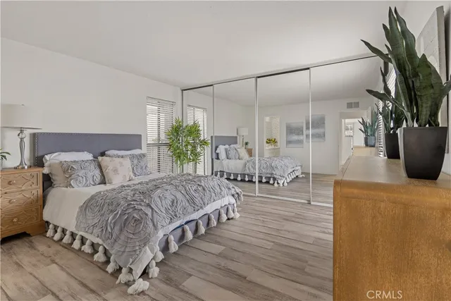 a living room with a balcony a bed and a potted plant