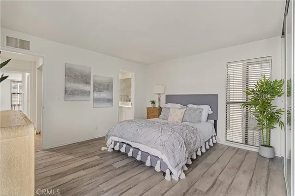 a bedroom with a large bed and a potted plant