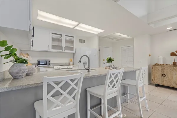 a white kitchen with a table and chairs