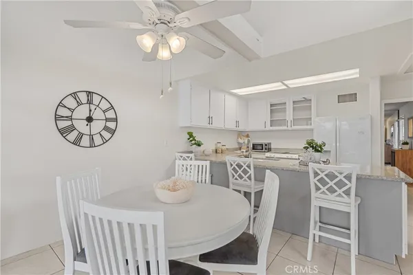 a view of a dining room with furniture a kitchen and chandelier