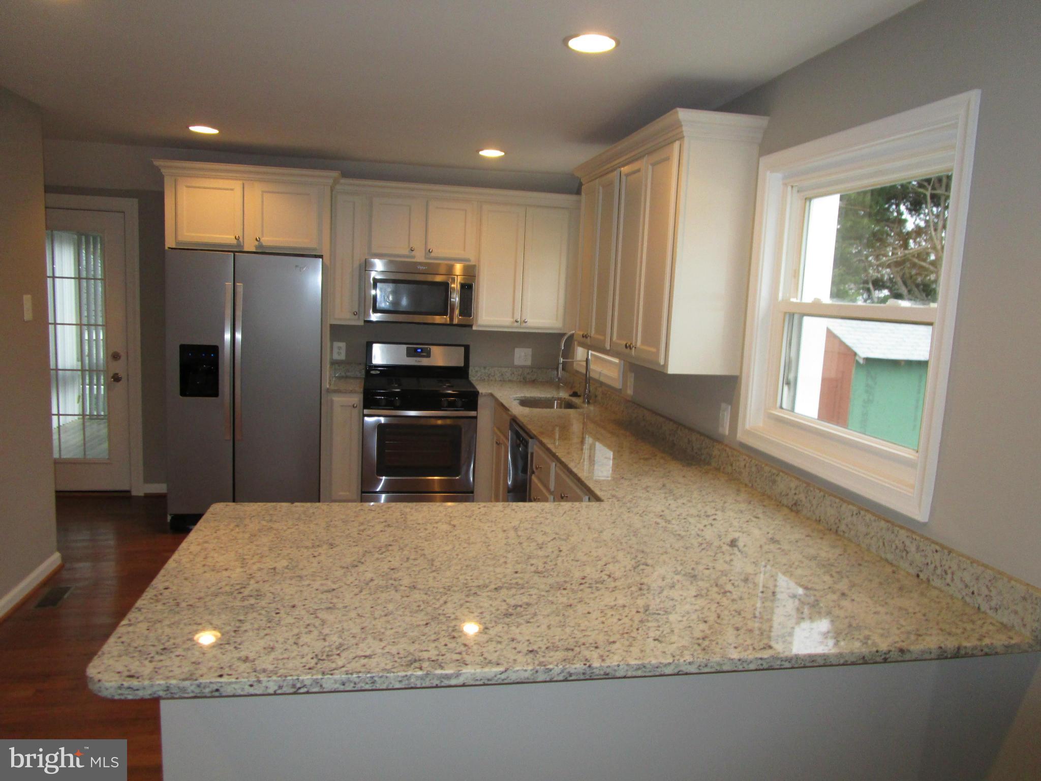 12704 Holdridge Road Silver Spring, MD 20906 - Photo 4 of 22 a kitchen with stainless steel appliances granite countertop a sink a stove and a refrigerator