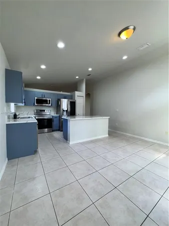 a kitchen with stainless steel appliances a refrigerator and a stove top oven