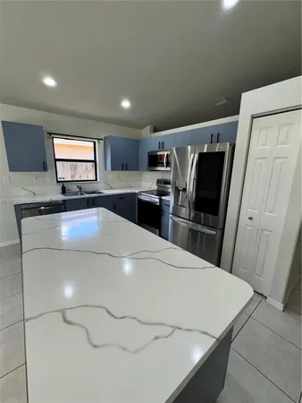 a kitchen with stainless steel appliances a refrigerator sink and microwave