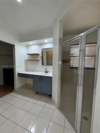 a bathroom with a double vanity sink mirror and shower