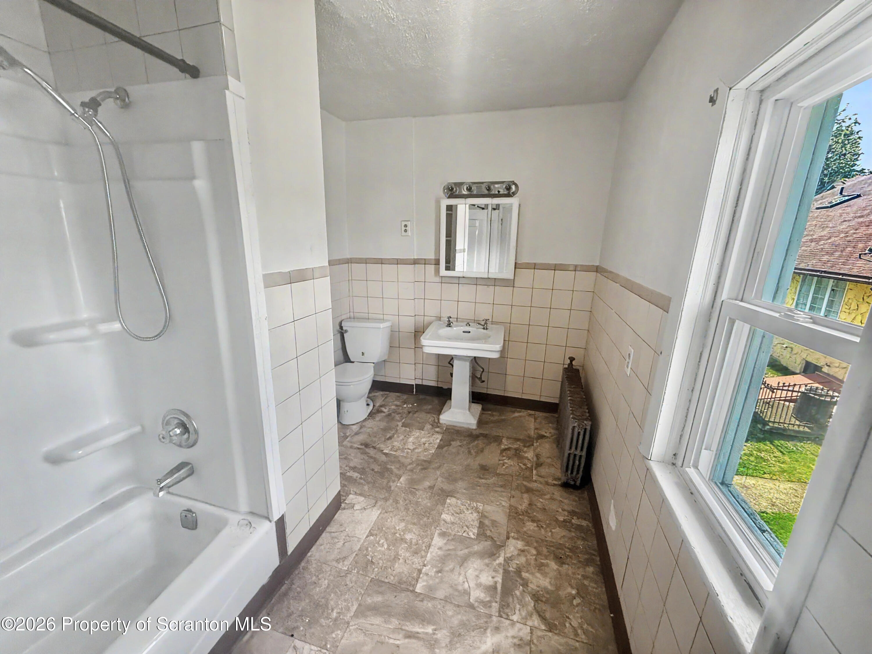 1315 Farr Street, Unit 2 Scranton, PA 18504 - Photo 6 of 7 a bathroom with a sink a toilet a window and a bathtub