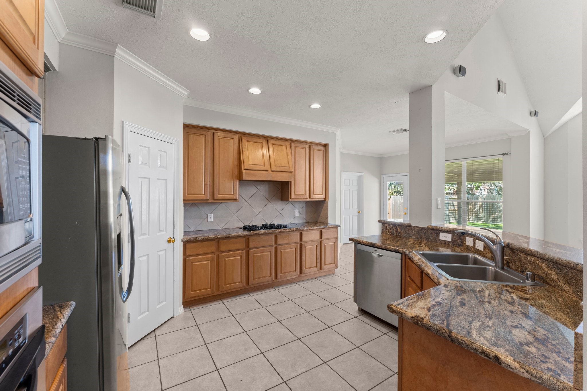 25814 Clear Springs Way Spring, TX 77373 - Photo 14 of 48 a kitchen with stainless steel appliances granite countertop a sink stove and refrigerator