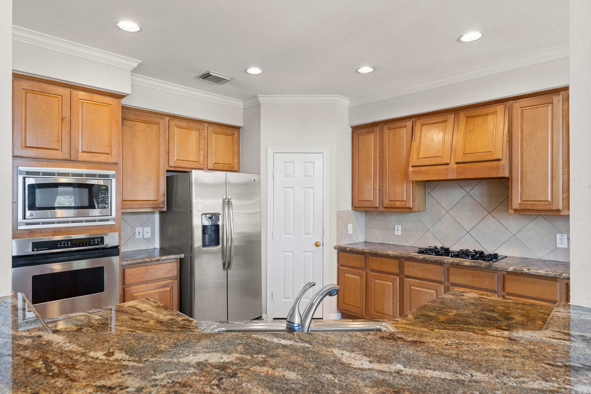 25814 Clear Springs Way Spring, TX 77373 - Photo 16 of 48 a kitchen with stainless steel appliances granite countertop a refrigerator a stove and a sink with wooden floors