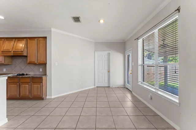 a view of an empty room with a fireplace and a ceiling fan