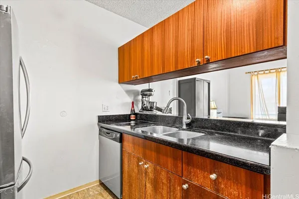 a kitchen with stainless steel appliances granite countertop a stove top oven a dining table and chairs with wooden floor