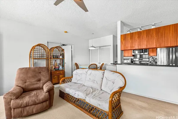 a kitchen with stainless steel appliances granite countertop a dining table chairs sink and refrigerator