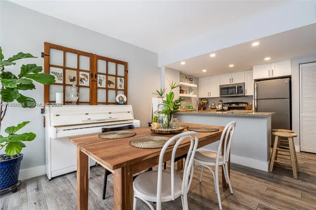a kitchen with a table chairs refrigerator and microwave