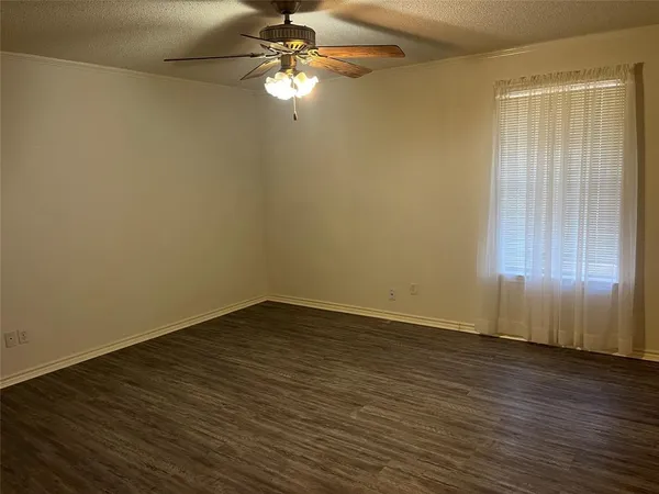 a view of a small space with wooden floor and a window