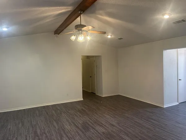 a view of a small space with wooden floor and a ceiling fan