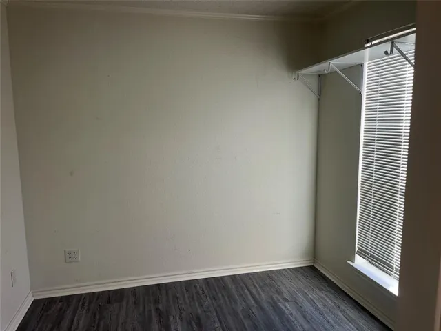 a view of a small space with wooden floor and a window