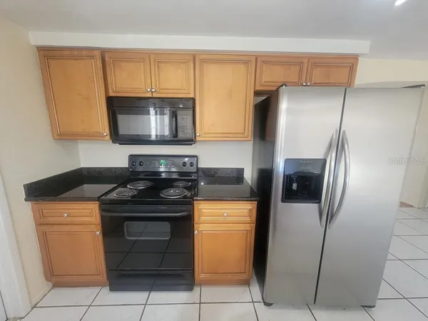 a kitchen with stainless steel appliances granite countertop a stove a refrigerator and a cabinets