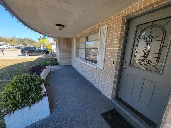 a view of a porch with furniture and floor to ceiling window
