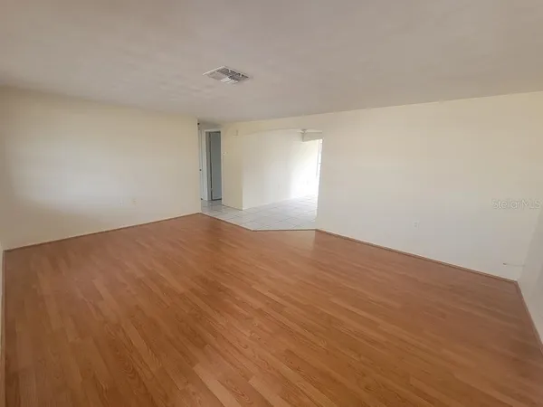 a view of empty room with wooden floor