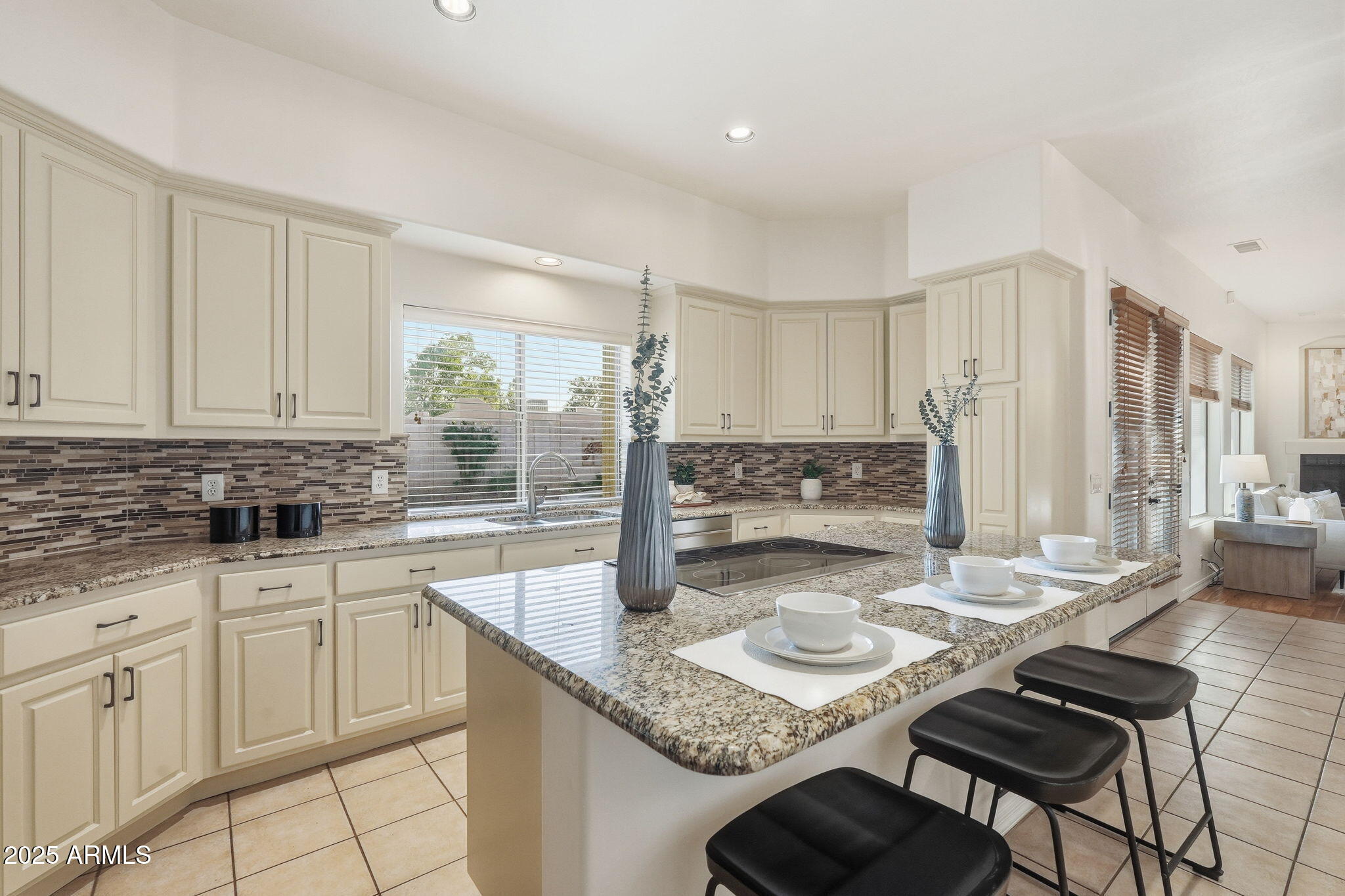 4409 East Janice Way Phoenix, AZ 85032 - Photo 15 of 41 a kitchen with kitchen island granite countertop a table chairs sink and cabinets