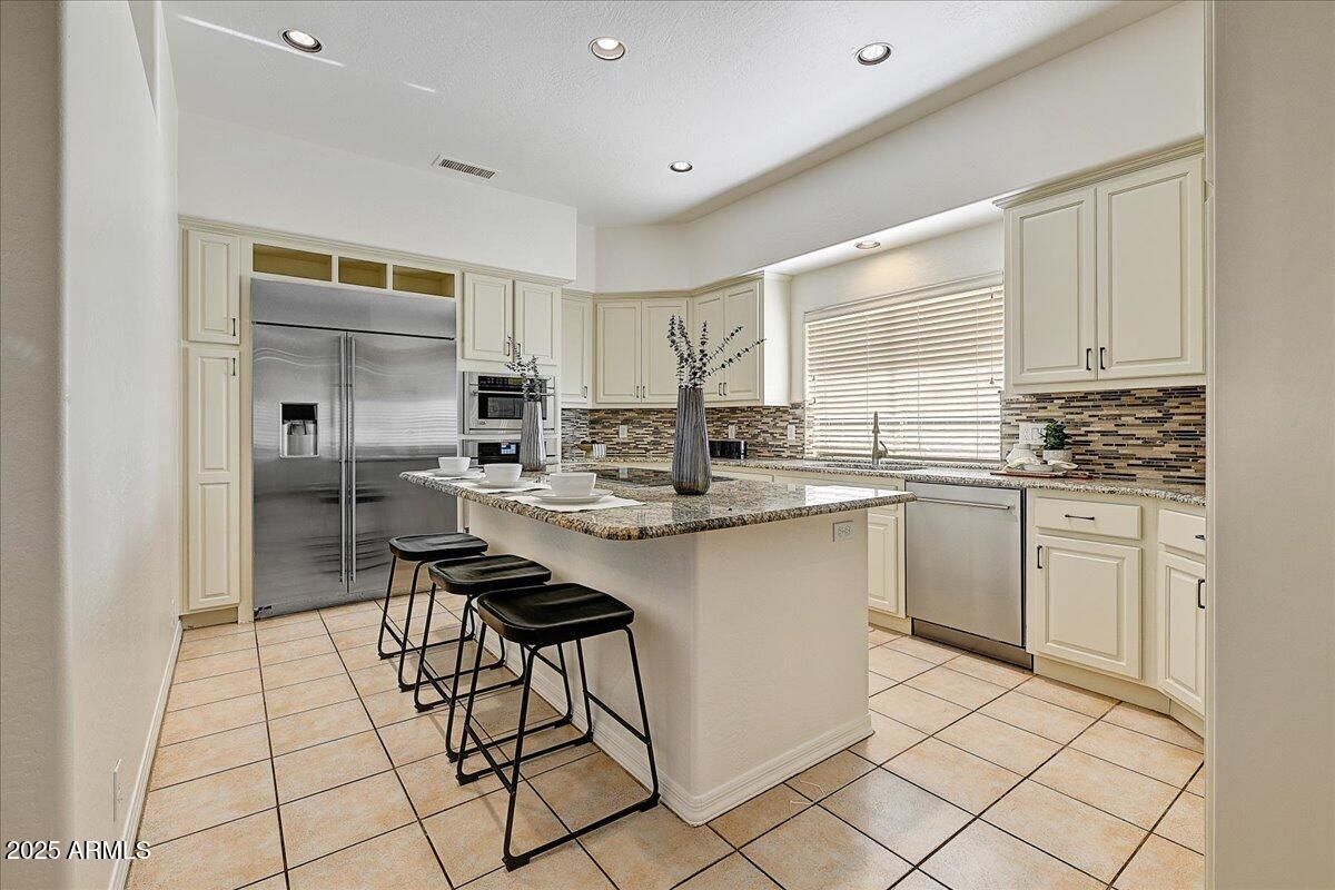 4409 East Janice Way Phoenix, AZ 85032 - Photo 17 of 41 a kitchen with stainless steel appliances kitchen island granite countertop a sink and cabinets