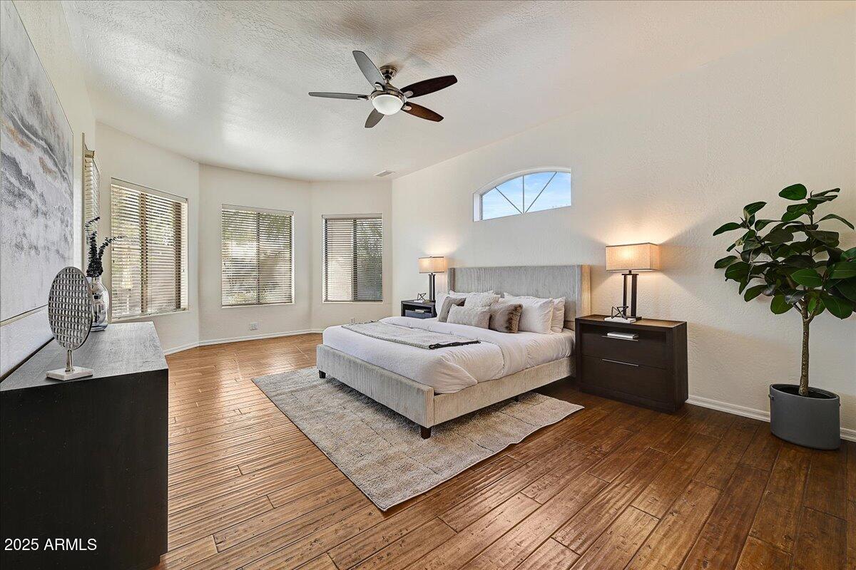 4409 East Janice Way Phoenix, AZ 85032 - Photo 20 of 41 a spacious bedroom with a bed and a chandelier