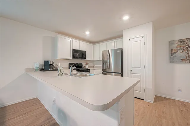 a kitchen with stainless steel appliances a refrigerator stove and microwave