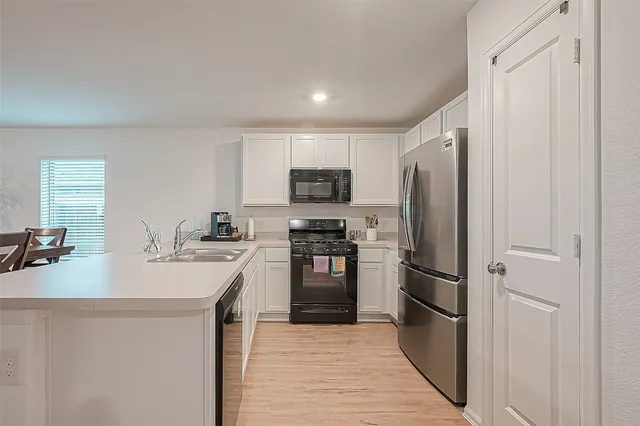 a kitchen with a sink cabinets and wooden floor