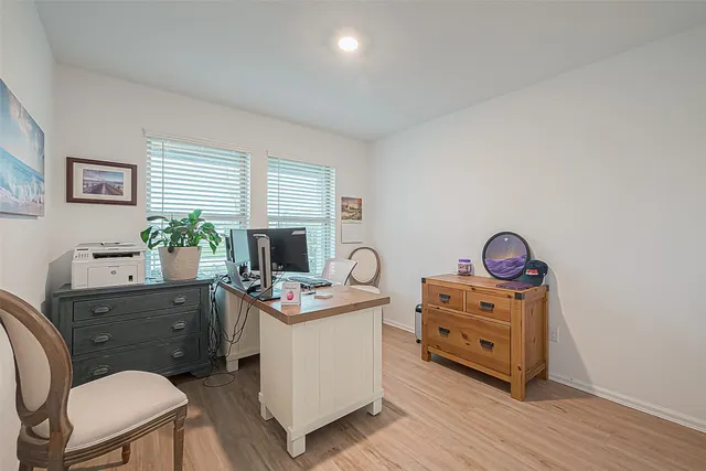 a view of a workspace with furniture and a window