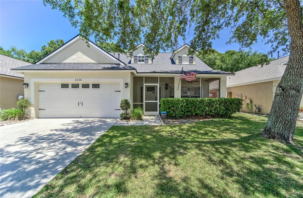 Beautiful, shaded front yard with sprinkler system installed and screened in front porch
