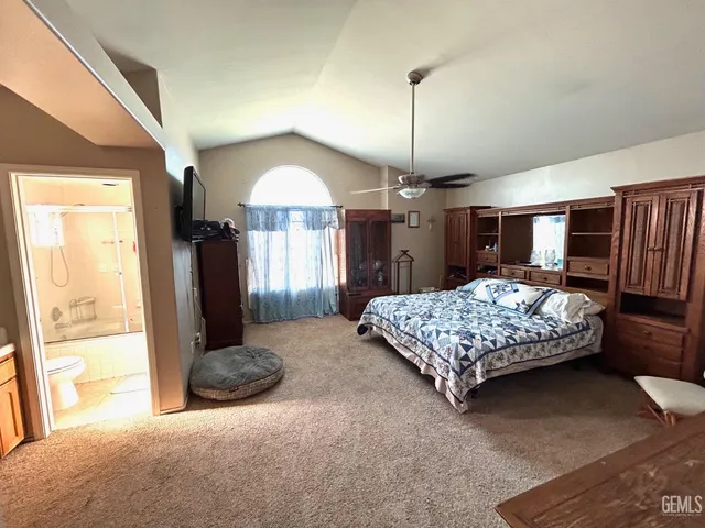 a bedroom with a large bed and a dresser next to a window