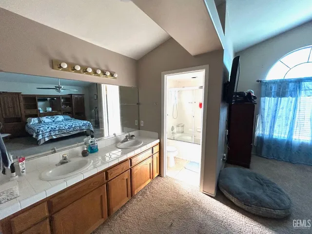 a spacious bathroom with a granite countertop sink a mirror and shower