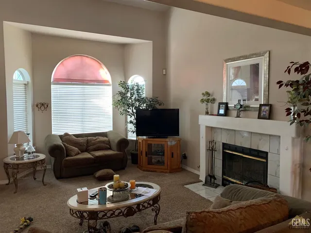 a living room with furniture a fireplace and a flat screen tv