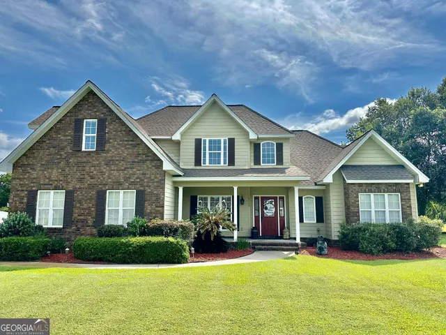 a front view of a house with swimming pool and green space