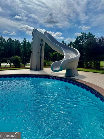 a view of a house with backyard and a tree