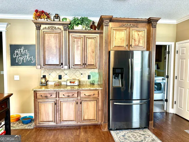 a kitchen with stainless steel appliances a refrigerator and wooden floor