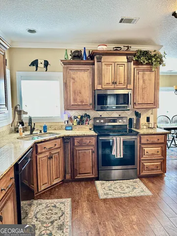 a kitchen with stainless steel appliances granite countertop a stove and a sink