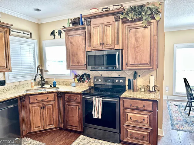 a kitchen with stainless steel appliances granite countertop a stove sink microwave and cabinets
