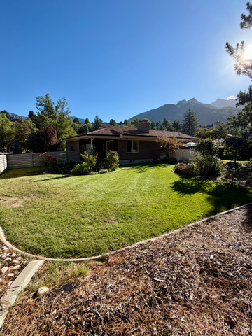 2924 Robidoux Road Sandy, UT 84093 - Photo 57 of 68 Expansive backyard featuring a manicured lawn, mature landscaping, and mountain backdrop