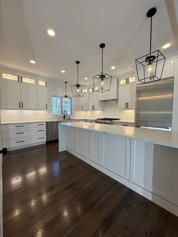a large kitchen with kitchen island a sink stainless steel appliances and cabinets