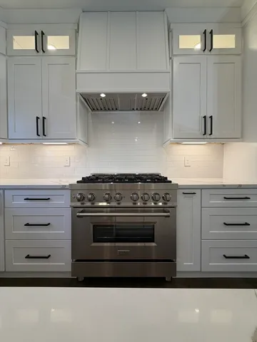 a stove top oven sitting inside of a kitchen