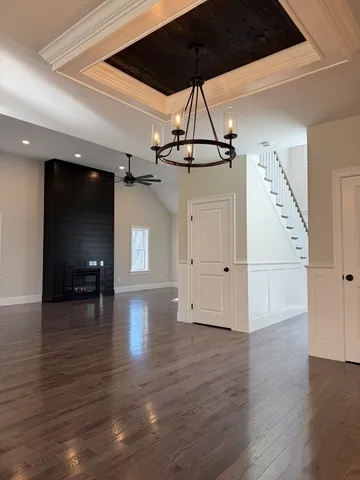 a view of a livingroom with wooden floor and a ceiling fan