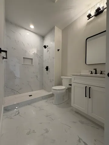 a bathroom with a double vanity sink toilet and shower