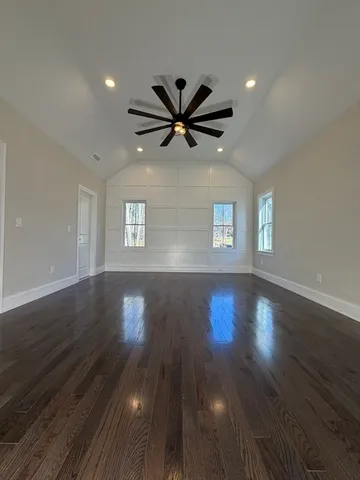 a view of an empty room with window and wooden floor