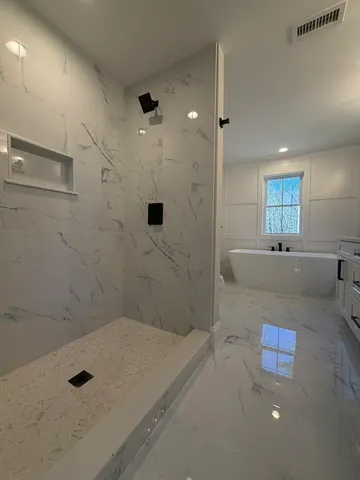 a bathroom with a tub shower and sink