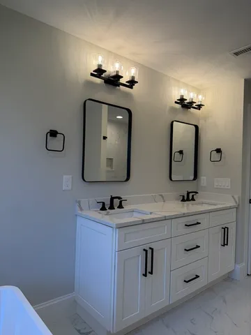 a bathroom with a double vanity sink and a mirror