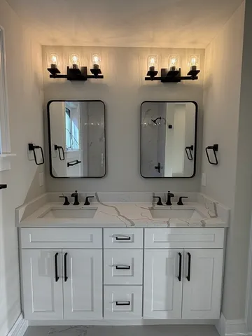 a bathroom with double vanity sinks and a mirror