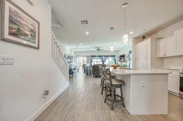 a kitchen with stainless steel appliances a dining table chairs refrigerator and microwave